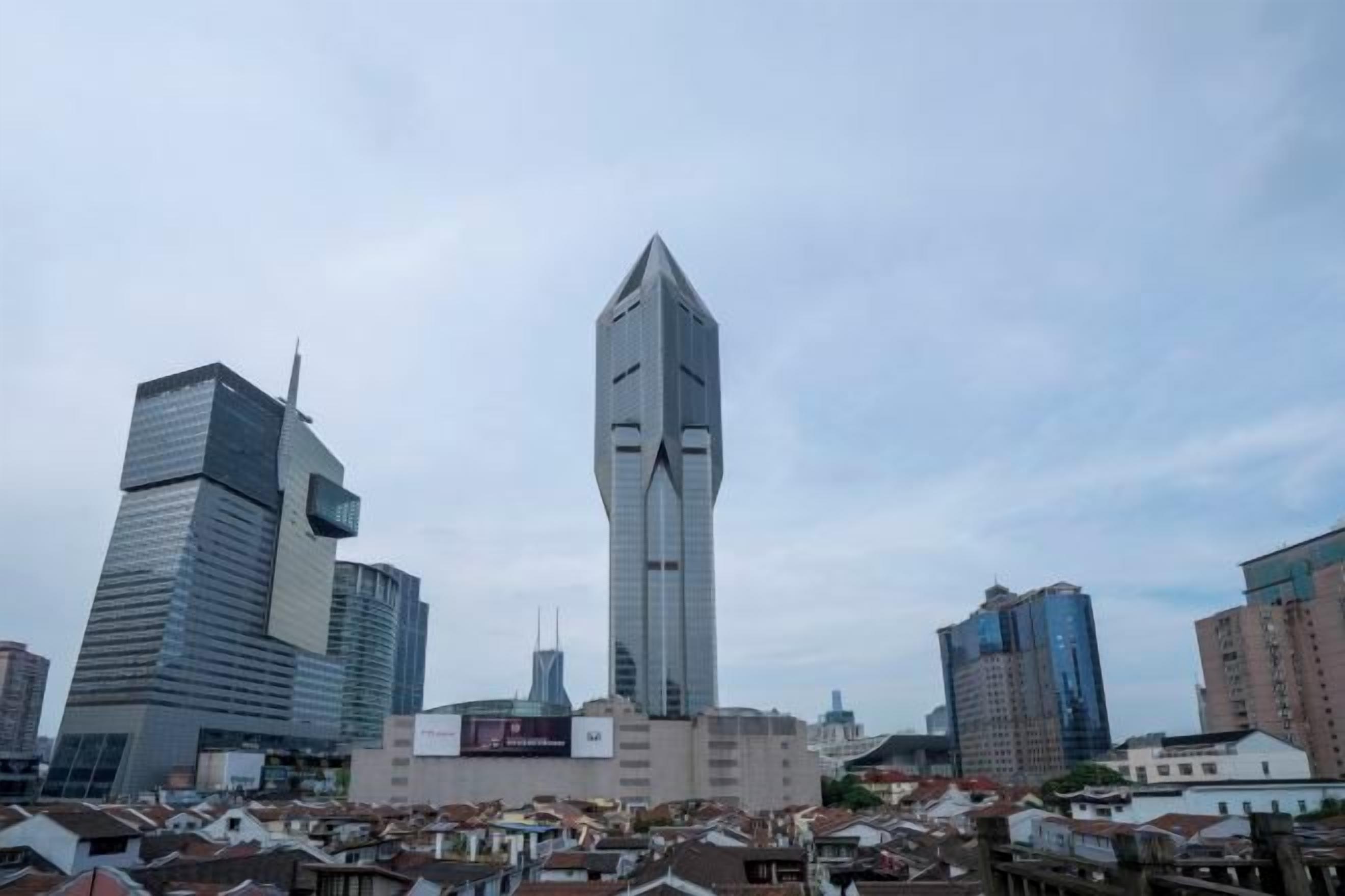 A cityscape with modern high-rise buildings, including a prominent skyscraper with a unique design.
