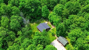 An aerial view of a house surrounded by dense green forest. - Amazing Starr Cabin | Hocking Hills, Hot Tub, 3BR (Rockbridge)