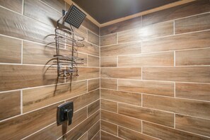 A corner of a bathroom with wooden tiles and a metal towel rack.