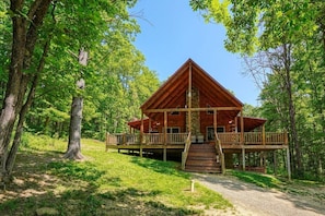 Eine Holzhütte mit einer Holzterrasse, umgeben von Bäumen.
