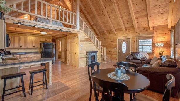 Un intérieur de cabine spacieux comprenant un coin repas, une cuisine et une chambre à coucher située en mezzanine.