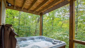 Un bain à remous dans un chalet en bois avec vue sur la forêt.