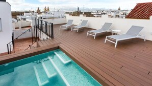 A rooftop pool with lounge chairs and a view of the cityscape.