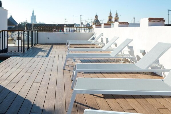 A rooftop terrace with wooden flooring and white sun loungers. - Old Town Building, Rooftop terrace with pool and views! - Several units (Sevilla)