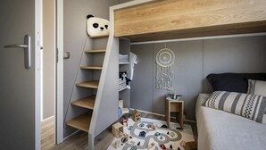 A bedroom with a bunk bed, a wooden staircase, a dreamcatcher, and a play area with toys. - Chalet by Hegermeer With Lake Access (Heeg)