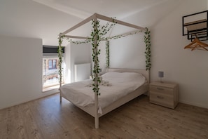 A bedroom with a four-poster bed, a bedside table, and a view of the outside. - Holiday Home in La Roche Near Center (La Roche-en-Ardenne)