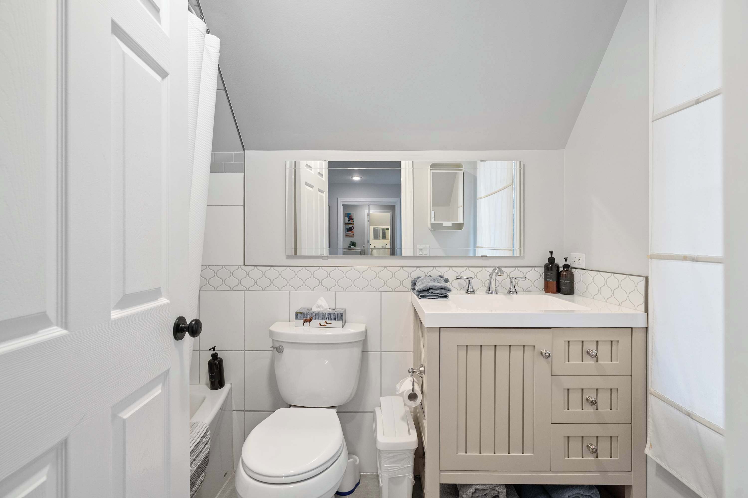 A bathroom with a toilet, sink, and cabinet.