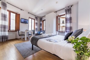 Une chambre d’hôtel moderne avec un grand lit, un bureau et une vue sur la ville.