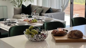 Ein Esstisch, gedeckt mit Tellern, Gläsern und einer Obstschale.