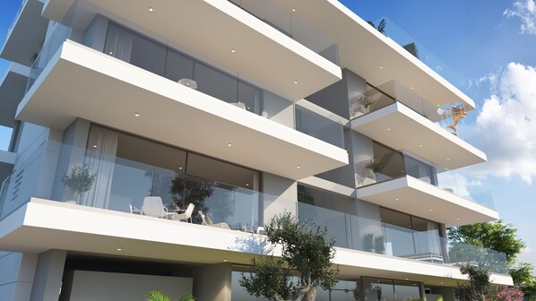 Un edificio moderno de varios pisos con balcones, ventanas amplias y cielo despejado.