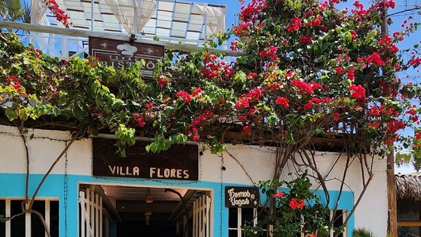 Un edificio llamado 'Villa Flores' con un cartel que indica un bistró.