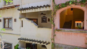 A multi-story building with balconies, a staircase, and a ceiling fan. - Mission Gate 3B, 2-bedroom condo by Island House Vacation Rentals (West Bay)