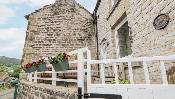 A stone building with a white gate and flower boxes. - Bank Cottage (Hope Valley)