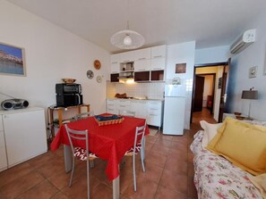A compact living space with a dining area, kitchenette, and a sofa. - Casa Marina di Castelsardo (Castelsardo)