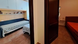 A room with a bed, a sofa, a small table, and a cabinet. - Casa Marina di Castelsardo (Castelsardo)