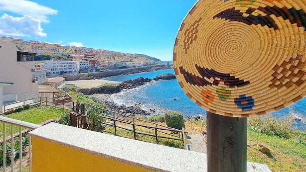 A coastal view with a woven basket on a balcony railing. - Casa Marina di Castelsardo (Castelsardo)