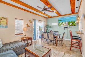 A spacious living room with a ceiling fan, a dining area with chairs and a table, and a large window with blinds. - Oceanview Villa w/ Private Rooftop & Pool (Marathon)
