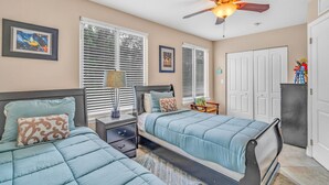 A bedroom with two beds, a ceiling fan, and a nightstand with a lamp. - Oceanview Rooftop Retreat  3BR 3BA in Marathon FL (Marathon)