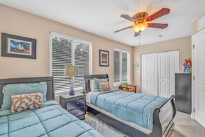 A bedroom with two beds, a ceiling fan, and a nightstand with a lamp. - Oceanview Rooftop Retreat  3BR 3BA in Marathon FL (Marathon)