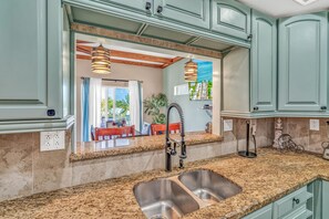 A kitchen with granite countertops, stainless steel sinks, and teal cabinetry. - Oceanview Villa w/ Private Rooftop & Pool (Marathon)