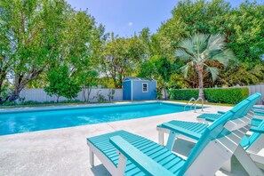 Une piscine avec des chaises longues et un petit abri bleu.