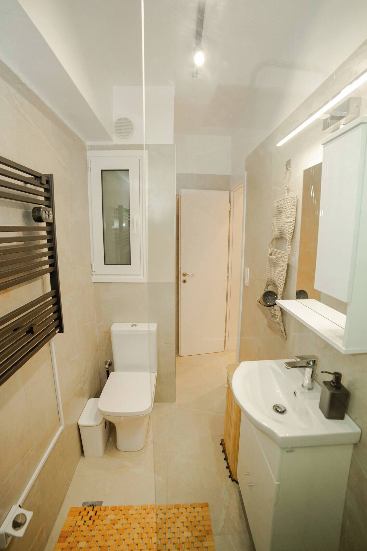 Een kleine badkamer met toilet, wastafel en spiegel.