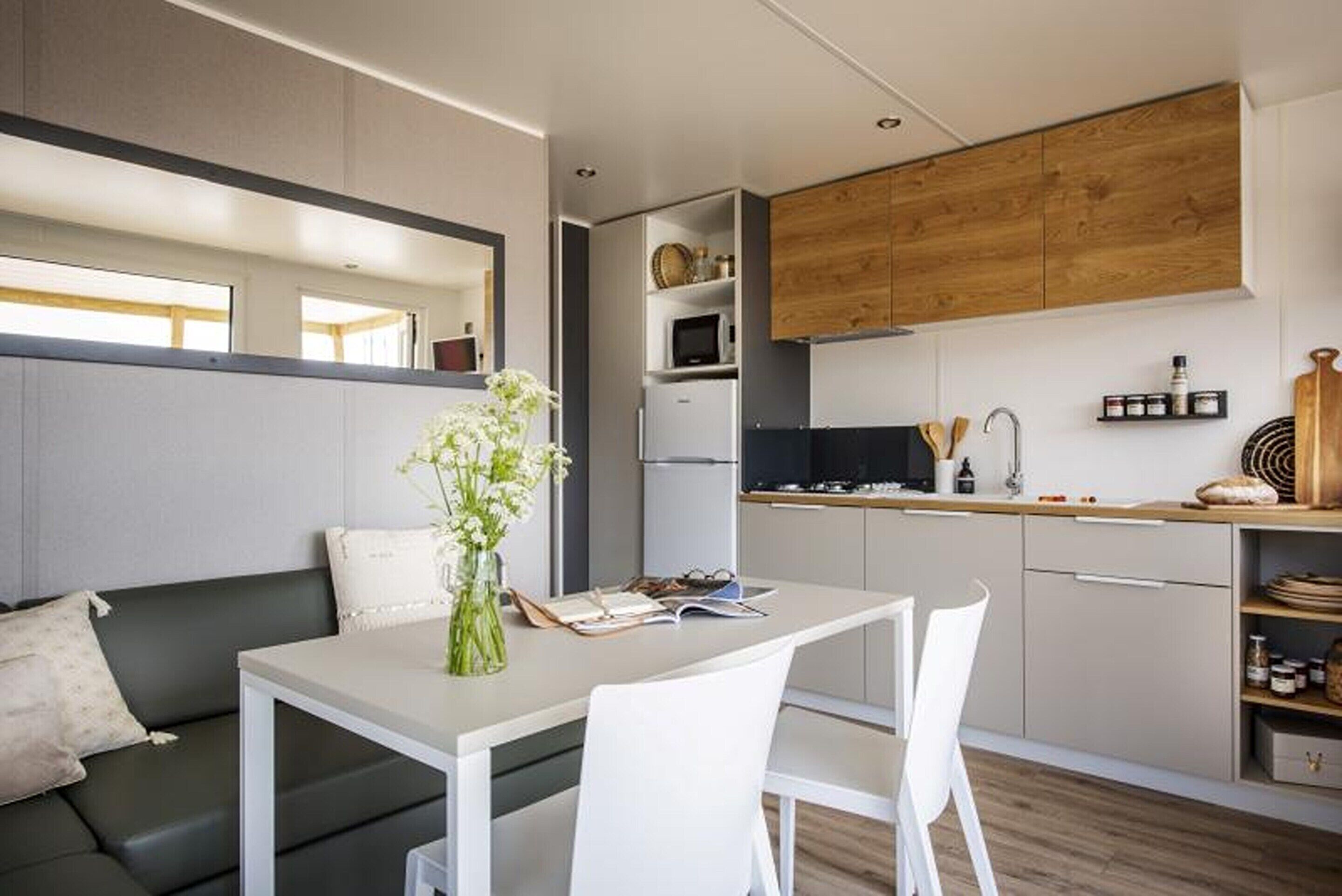 A compact living space with a kitchenette, a dining area, and a sofa.
