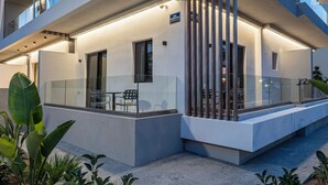 Un moderno edificio de varios pisos con balcones, amplias ventanas y una fachada bien iluminada.