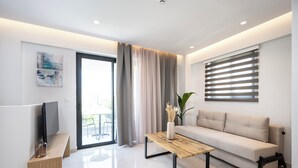 Una sala moderna con un sofá, una mesa de centro, un televisor y una obra de arte en la pared.