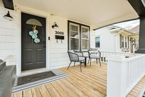 A porch with a black door, a mailbox, and a number 3008 sign.