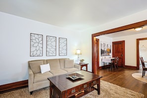 A living room with a sofa, coffee table, and artwork on the wall.