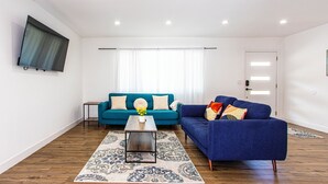 A modern living room with a teal sofa, a blue sofa, and a coffee table. - 3BR Palm Springs Oasis (Palm Springs)