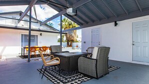 An outdoor patio with a table and chairs, a ceiling fan, and a door. - 3BR Palm Springs Oasis (Palm Springs)