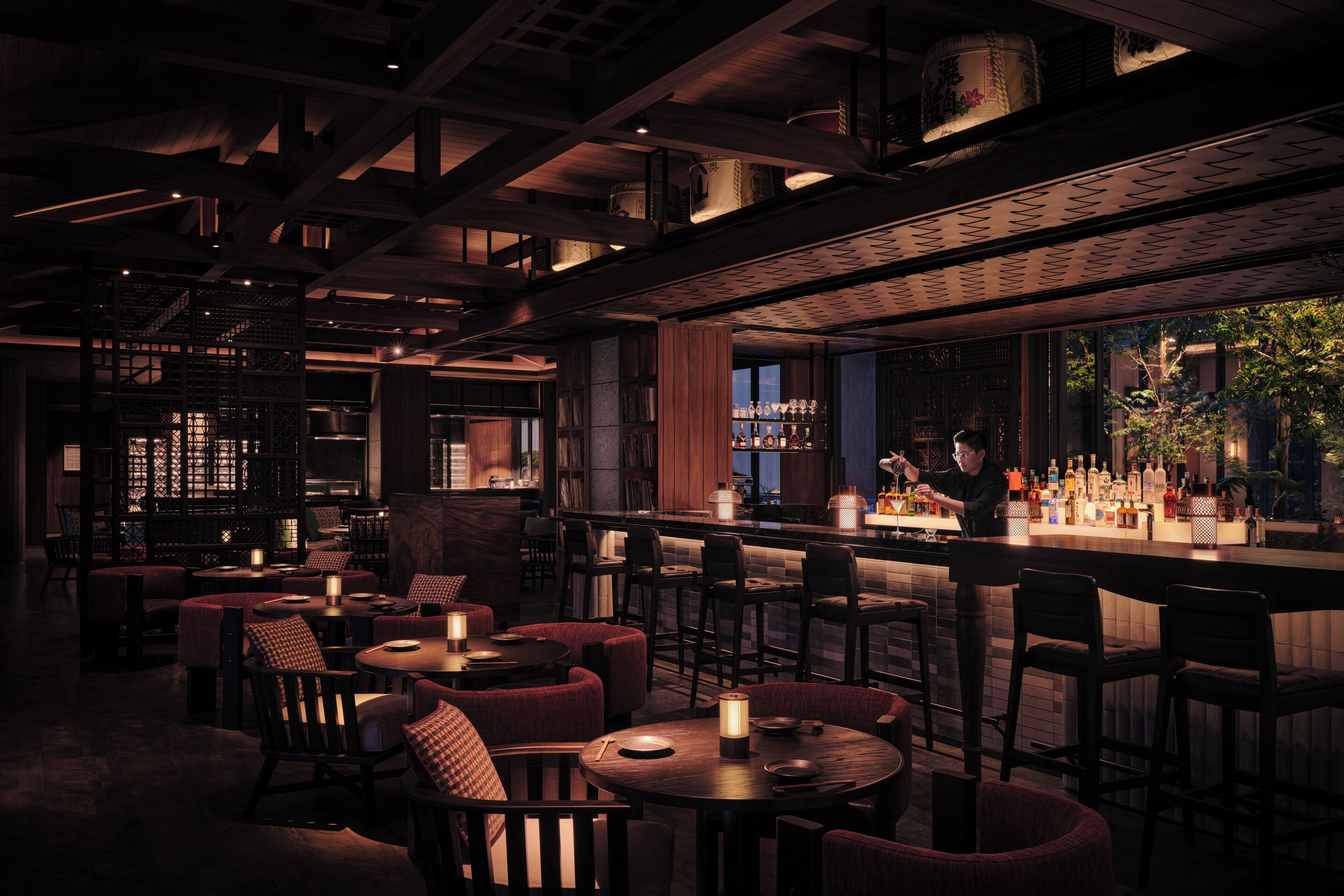 A dimly lit bar area with wooden furniture and a bartender at the counter.