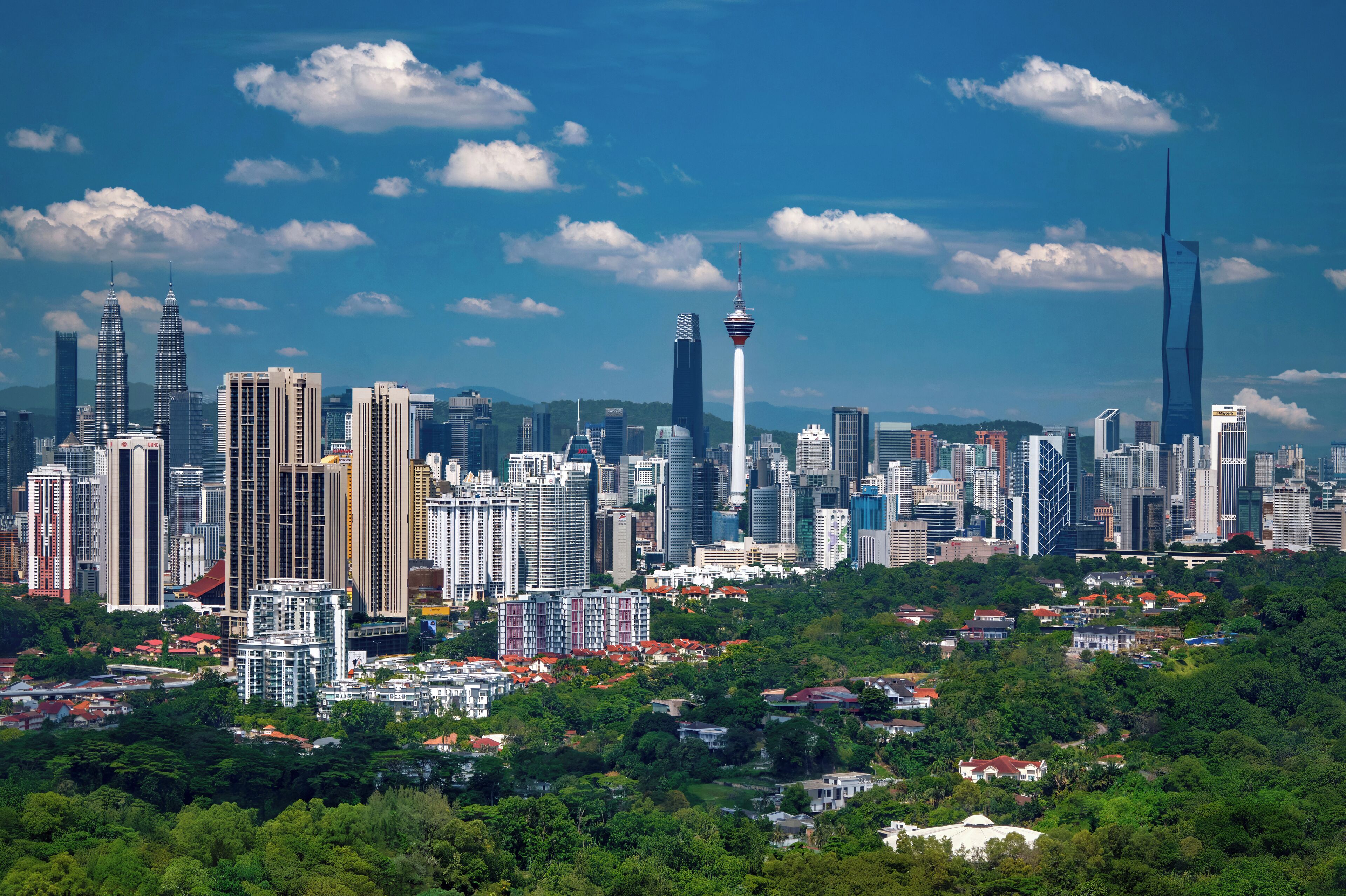 Un paisaje urbano con edificios altos, una torre destacada y una combinación de construcciones residenciales y comerciales.
