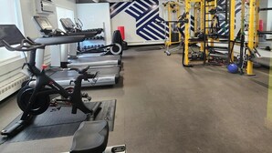 A gym with treadmills, stationary bikes, and a weightlifting area. - Downtown Suite Living! (Minneapolis)