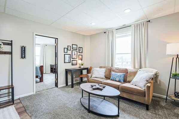 Een moderne woonkamer met een bank, salontafel en wanddecoratie.