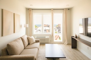 A modern living room with a sofa, a coffee table, and a TV on a wooden stand.