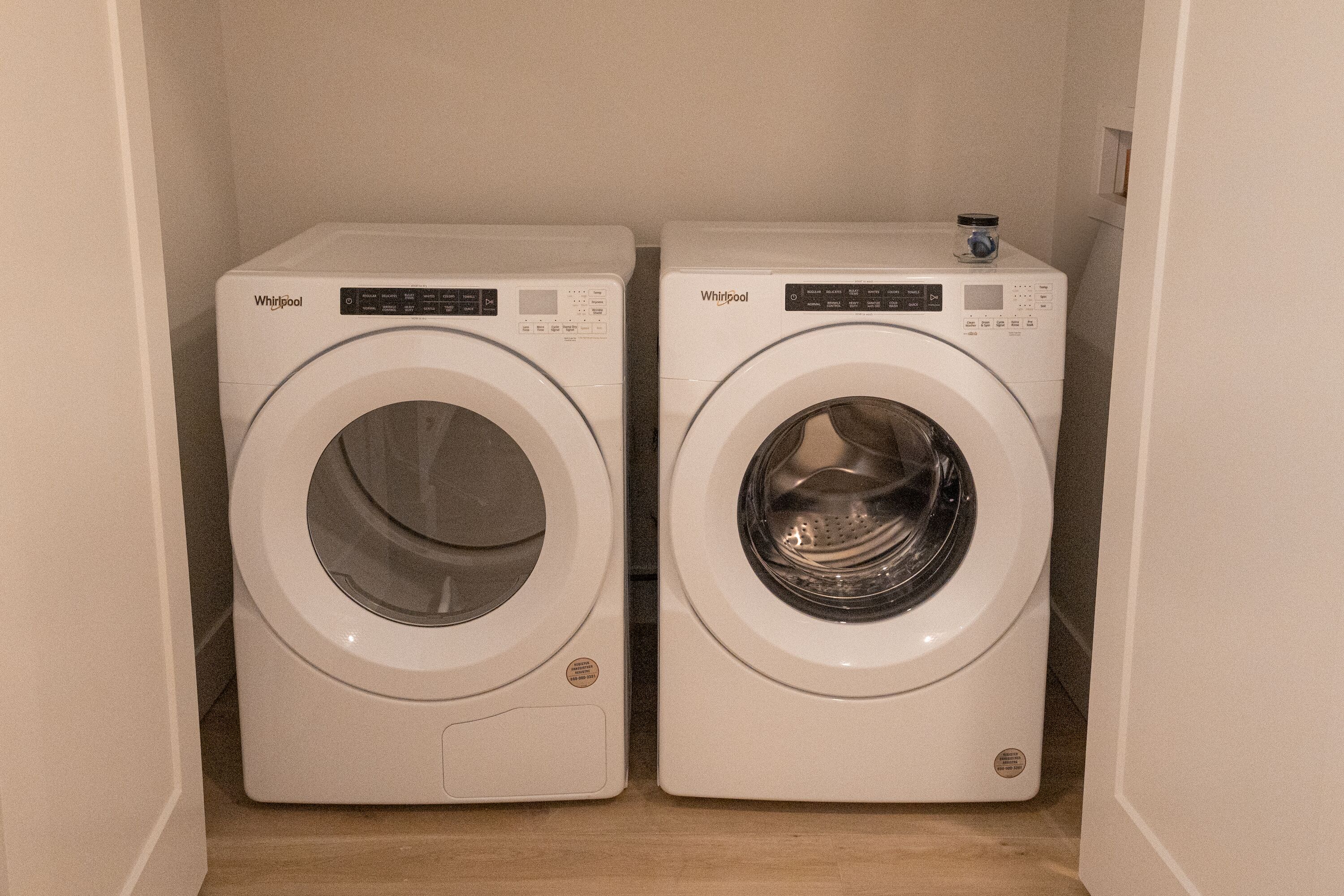 Twee Whirlpool voorladers in een wasserij met een houten vloer.