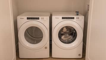 Twee Whirlpool voorladers in een wasserij met een houten vloer.