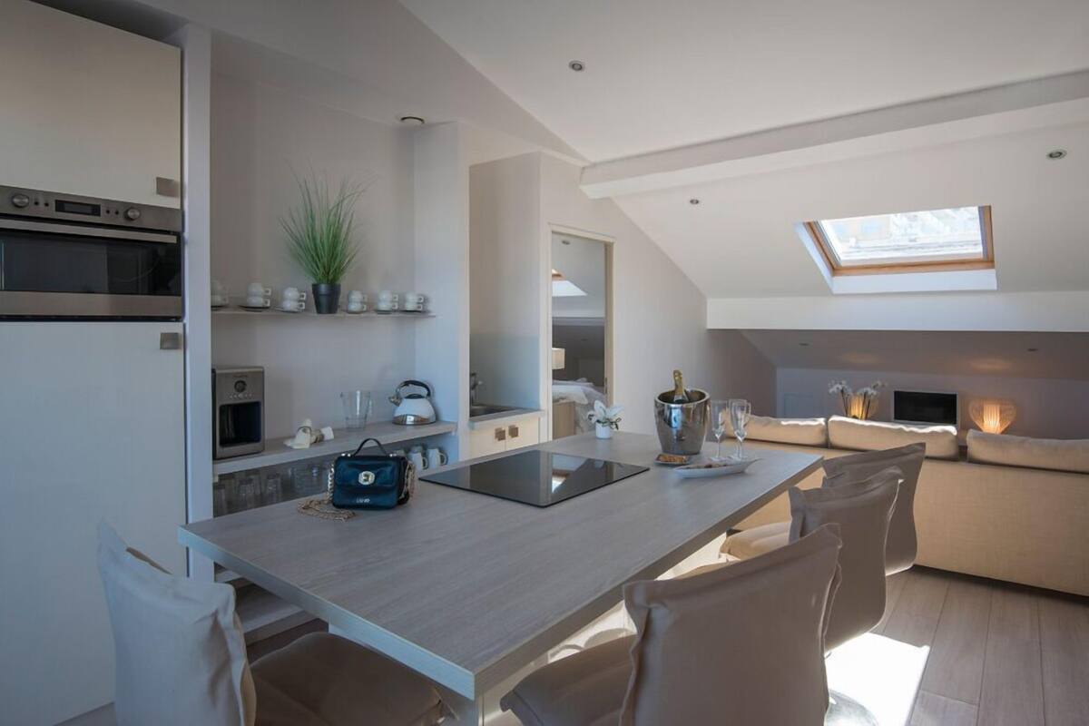 A modern kitchen with a central island, built-in appliances, and a skylight.