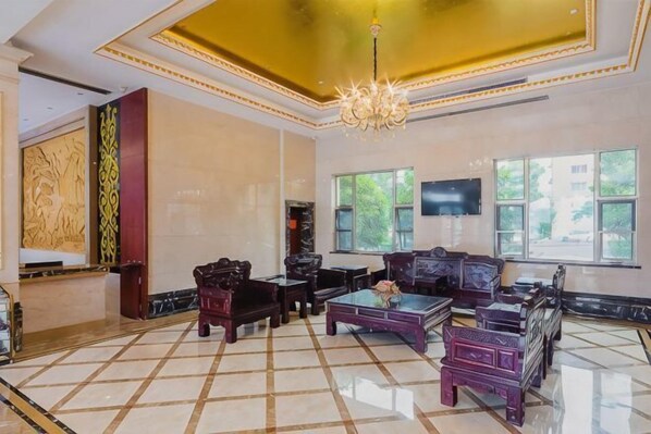 Una habitación amplia con candelabro, ventanas grandes y muebles tradicionales.