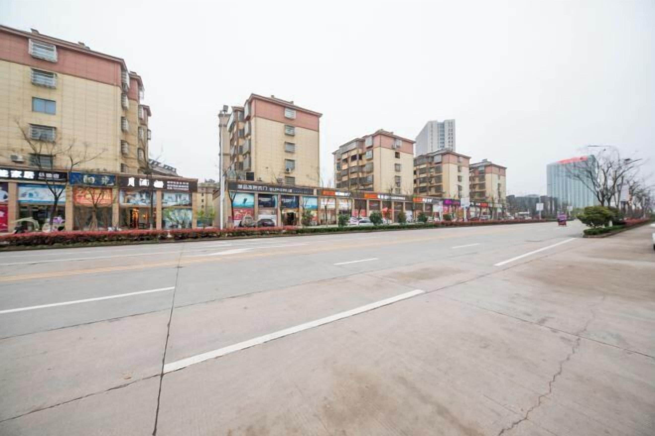 A street with multiple-story buildings, some with commercial establishments on the ground floor.