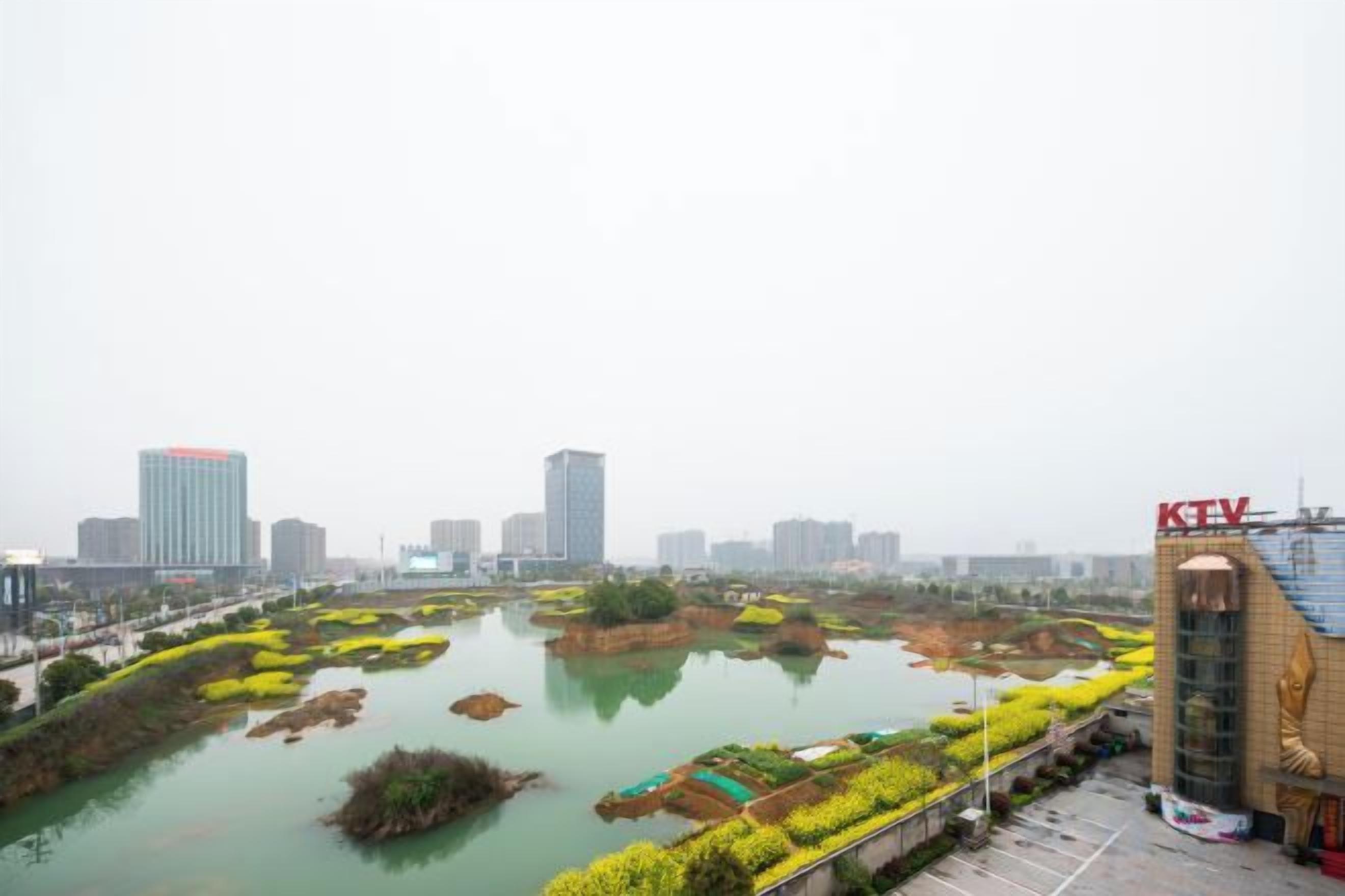A riverside view with a bridge, a KTV building, and a cityscape in the background.