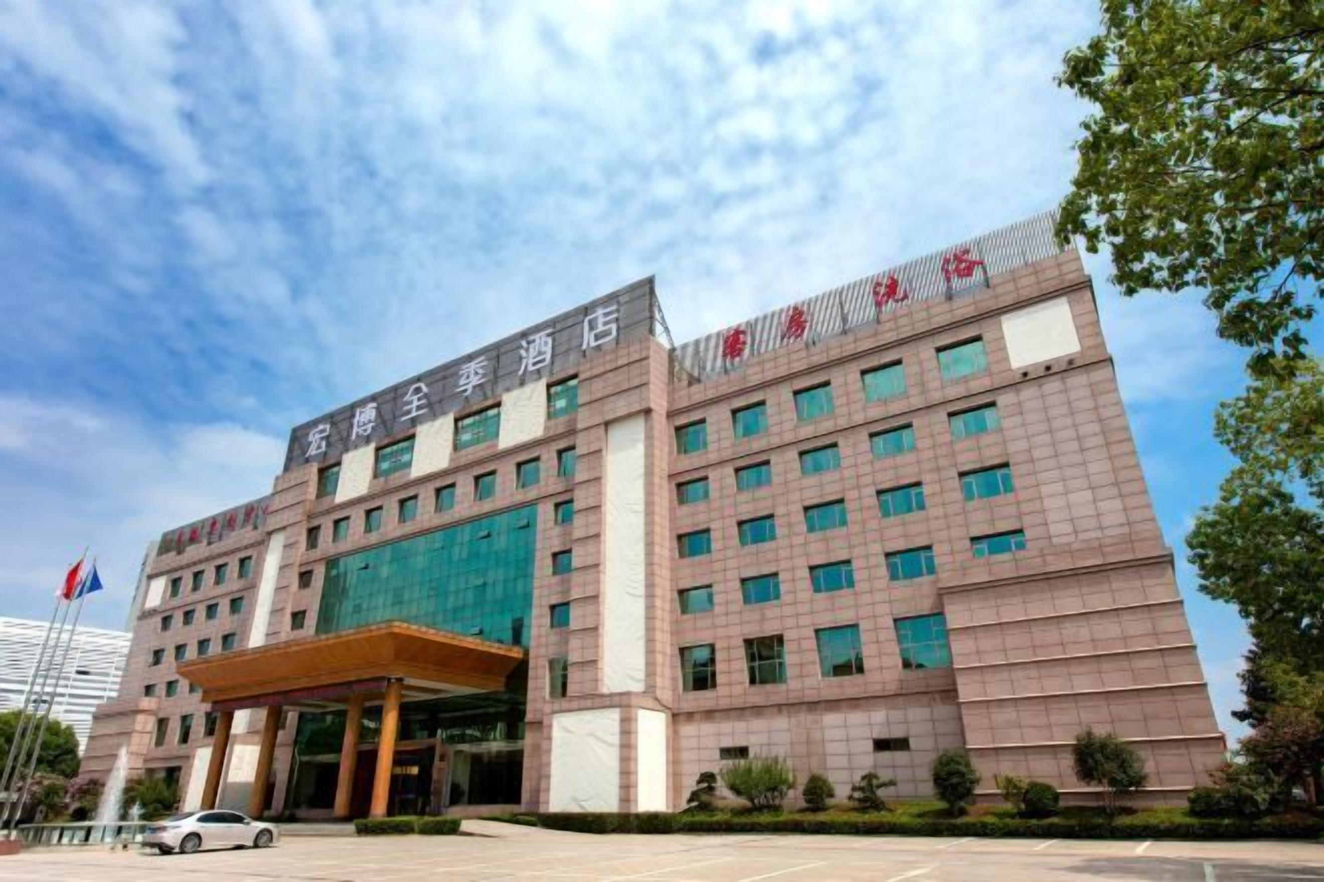 A hotel with a modern facade, multiple floors, and a prominent entrance.