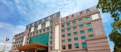 A hotel with a modern facade, multiple floors, and a prominent entrance.