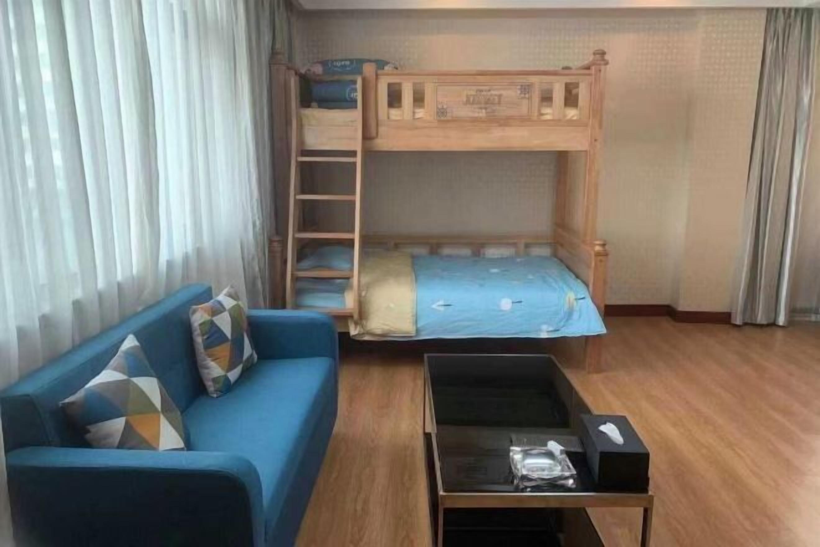 Una stanza con un letto a castello, una divano e un tavolino.