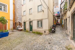 Een smalle straat met keien, geflankeerd door gebouwen.