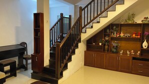 A staircase with wooden railings and a landing area with a bookshelf and decorative items.