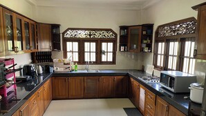 A kitchen with wooden cabinets, a black countertop, and a window with decorative glass.